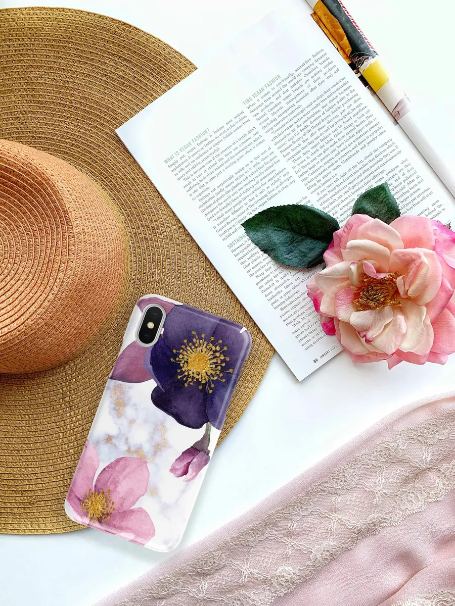 Pink and black floral phone case resting on a book